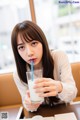 A woman sitting at a table with a glass of milk.