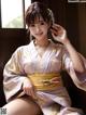 A woman in a kimono sitting on a window sill.