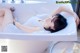 A woman laying in a bathtub with her legs crossed.