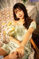 A woman sitting on a chair holding a bunch of flowers.