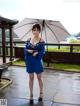 A woman in a blue dress holding an umbrella.