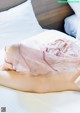 A woman laying on a bed in a pink lingerie.