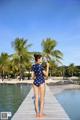 A woman in a polka dot swimsuit standing on a dock.