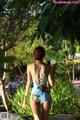 A woman in a blue swimsuit holding a drink.