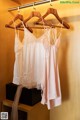 A couple of white and pink lingerie hanging on a rack.