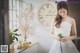 A woman in a wedding dress holding a flower.