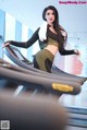 A woman in a black top and leggings on a treadmill.