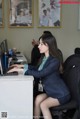 A woman sitting at a desk using a laptop computer.