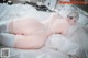 A woman laying on a bed in a white lingerie.