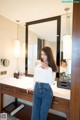 A woman standing in front of a mirror in a bathroom.