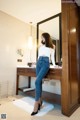 A woman standing in front of a mirror in a bathroom.