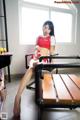 A woman sitting on a chair in front of a pool table.