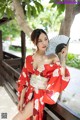 A woman in a red kimono holding a fan.