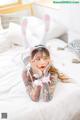 A woman laying on a bed with a cat ears headband.