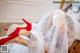 A woman in a wedding dress and red high heels.