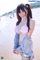 A woman in a pink bikini standing on a beach.