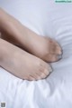 A close up of a person's feet on a bed.