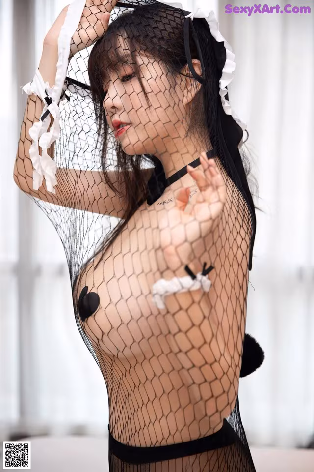 A woman in a black and white lingerie is posing for the camera.