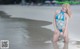 A woman in a blue bikini standing in the water.